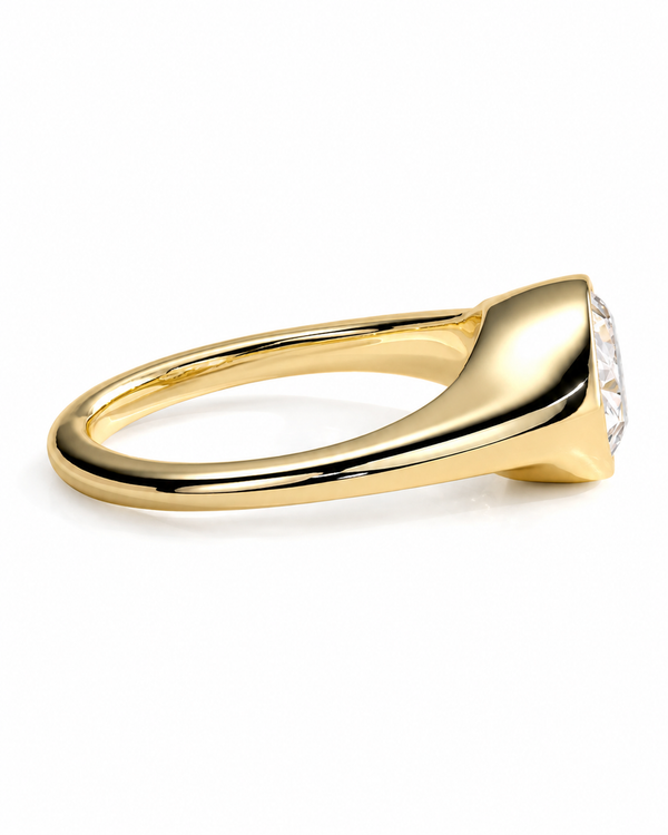 color_10K_YG, color_14K_YG &&A polished yellow gold ring with a tapered shank and a single round clear gemstone in a bezel setting, shown from a side profile on a white background.