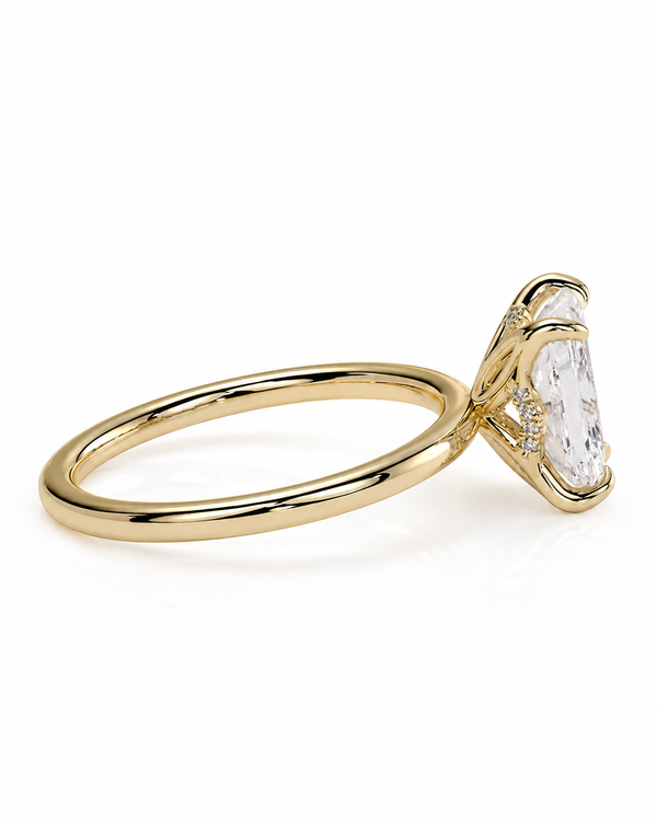 color_10K_YG, color_14K_YG &&A gold ring with a large clear pear-cut center stone and small clear accent stones on a plain white background.