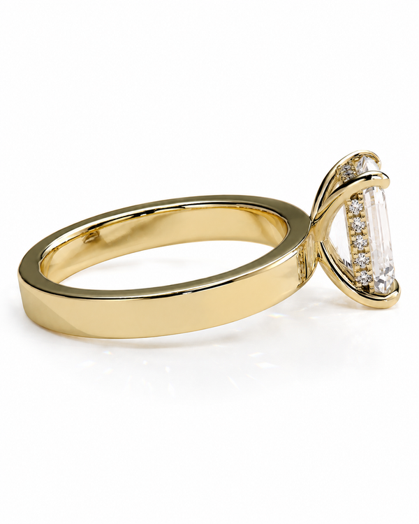 color_10K_YG, color_14K_YG &&A yellow gold ring with a curved band and a clear baguette-cut center stone accented by small side stones, shown on a white background.