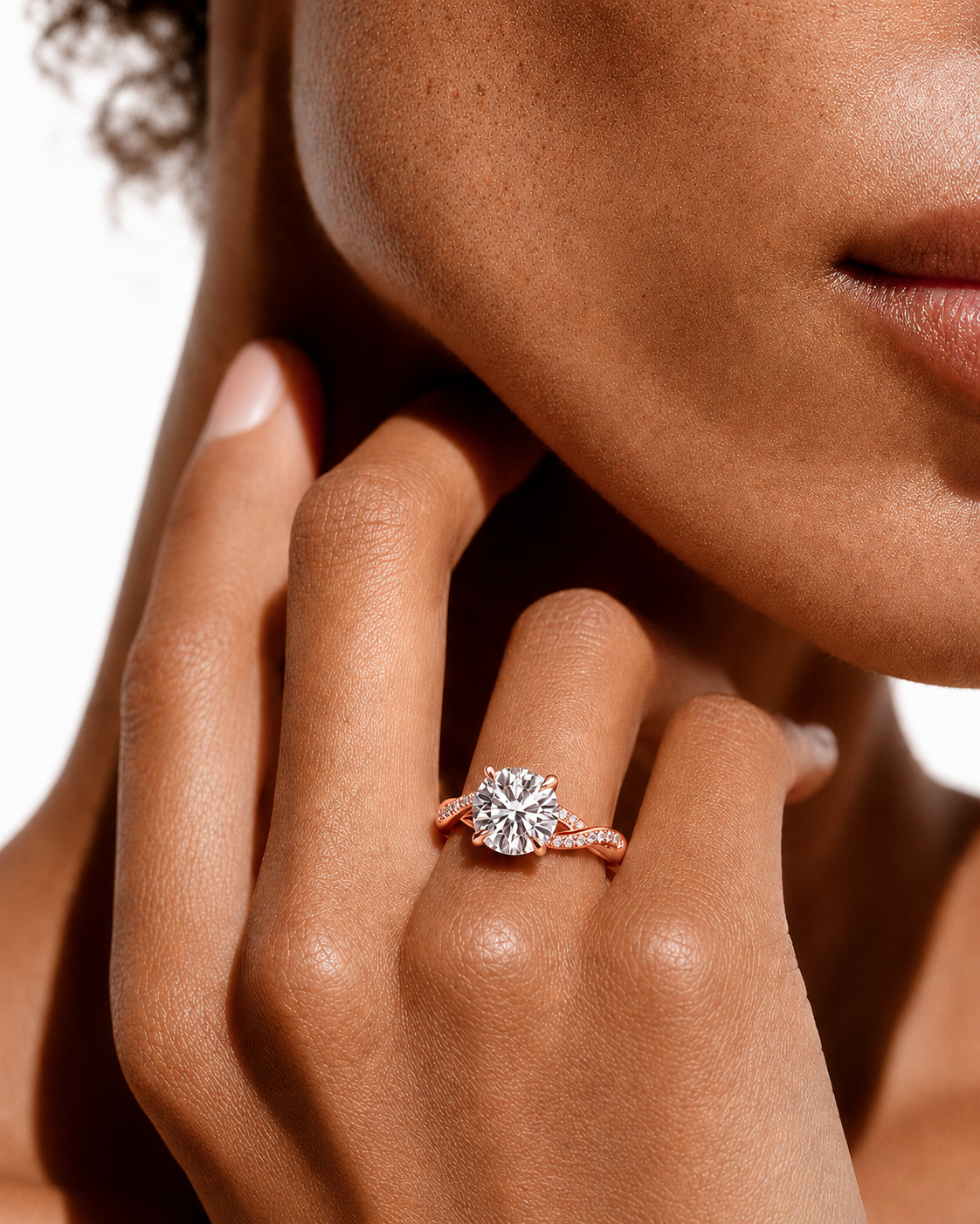 color_10K_RG, color_14K_RG &&
A close-up lifestyle shot of a model's hand wearing a rose gold ring with a large round-cut diamond. The ring is shown on the ring finger against a clean white background.