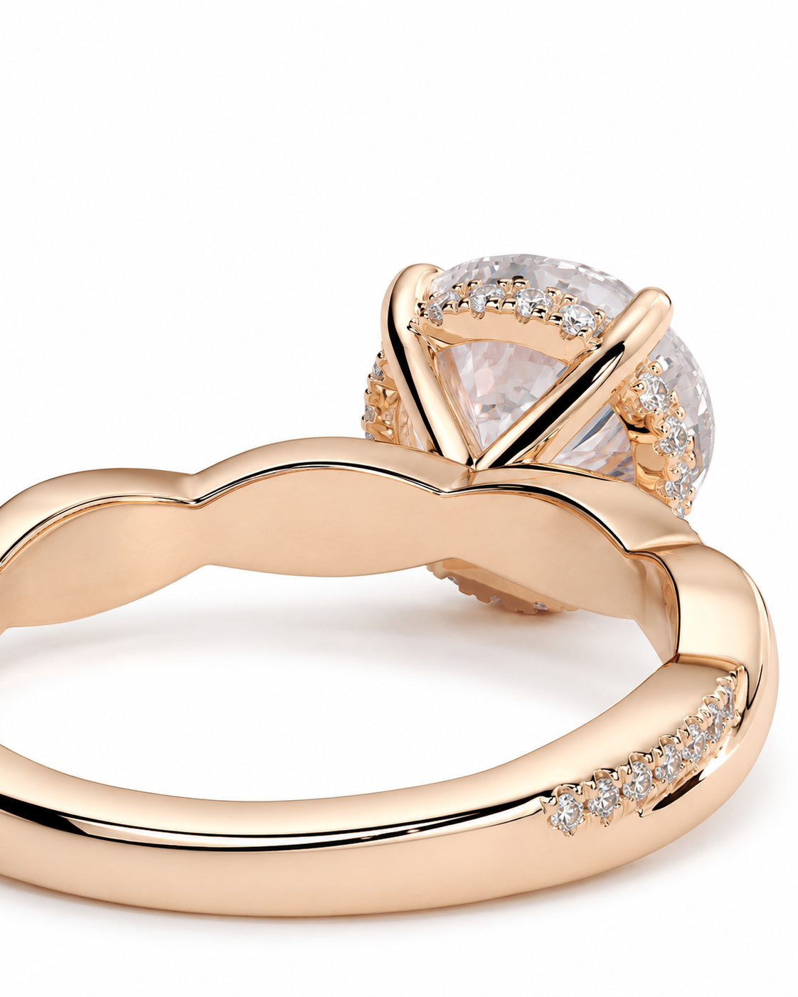 color_10K_RG, color_14K_RG &&
A close-up of a rose gold ring with a large clear round-cut center stone and a halo of small clear stones, set against a plain white background.