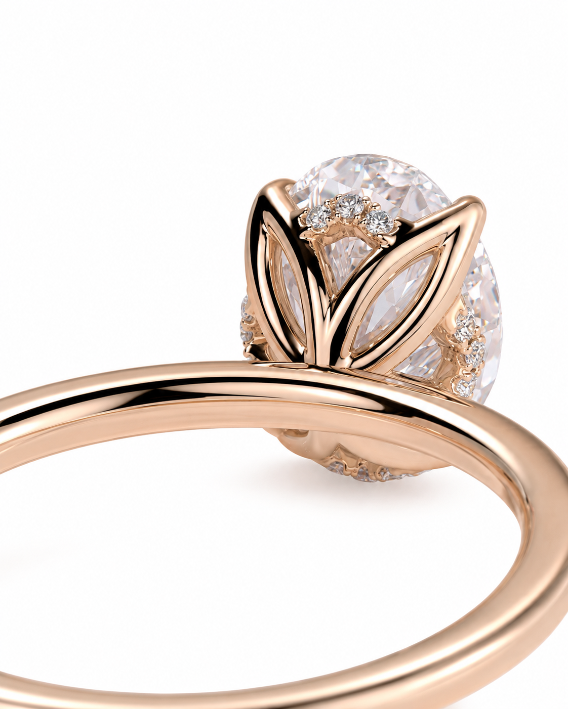 color_10K_RG, color_14K_RG &&
A close-up of a rose gold ring featuring a large oval clear gemstone in a leaf-like setting with smaller accent stones, shown on a clean white background.