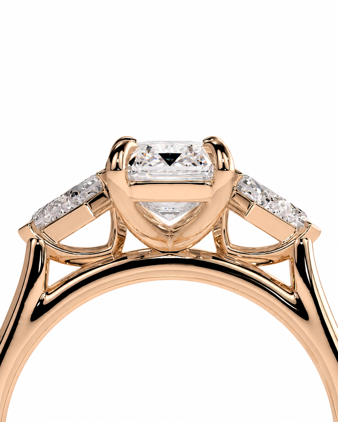 color_10K_RG, color_14K_RG &&
A close-up studio shot of a rose gold ring featuring a central rectangular diamond and two marquise-cut diamonds on the shoulders, set against a plain white background.