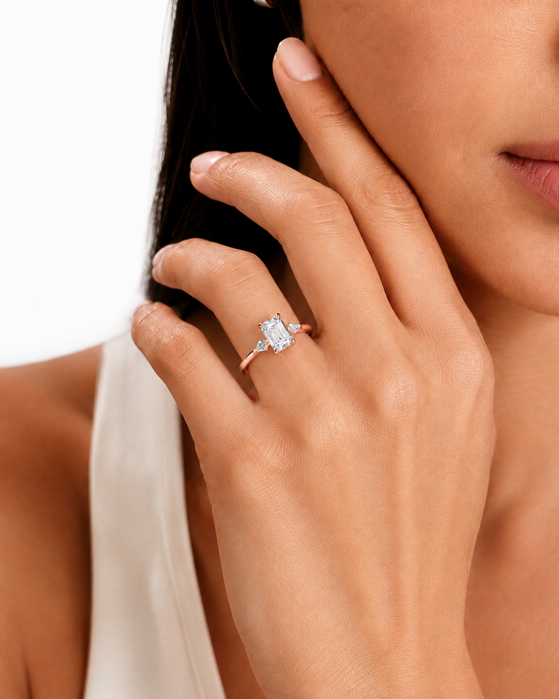 color_10K_RG, color_14K_RG &&
A close-up lifestyle shot of a model's hand wearing a rose gold ring with a marquise-cut clear gemstone. The ring is shown on the ring finger against a clean white background.