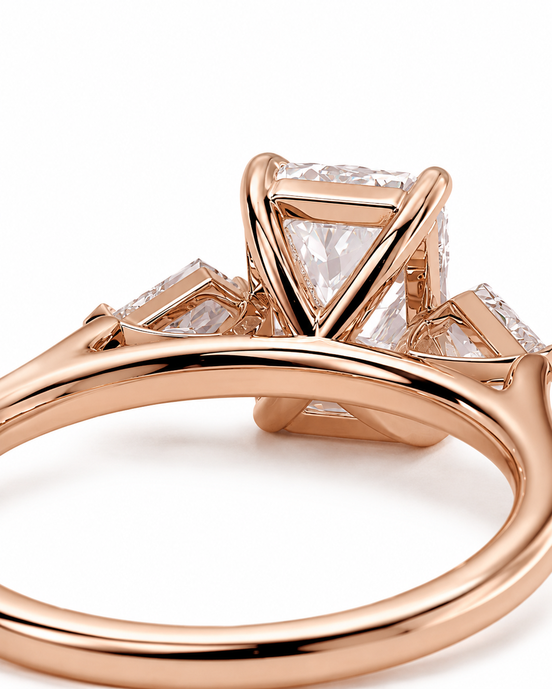 color_10K_RG, color_14K_RG &&
Rose gold ring with a triangular cluster setting featuring a central princess-cut diamond and two smaller side diamonds, shown on a white background.