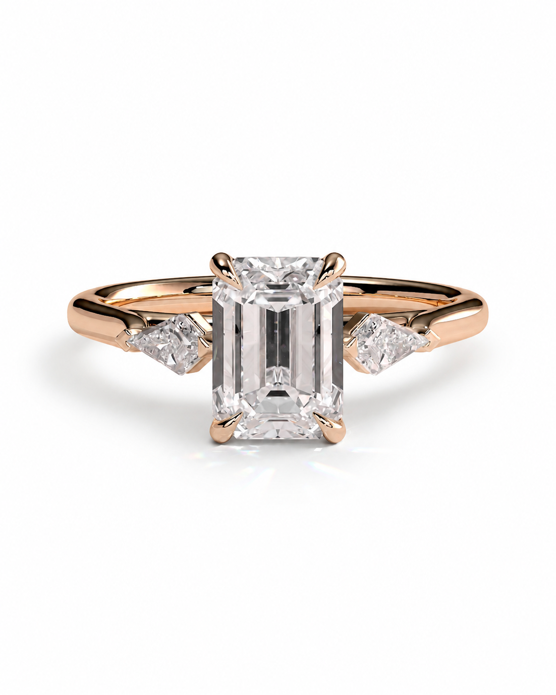 color_10K_RG, color_14K_RG &&
A rose gold engagement ring featuring a large emerald-cut diamond center stone and two smaller round diamonds on the shoulders, set against a clean white background.