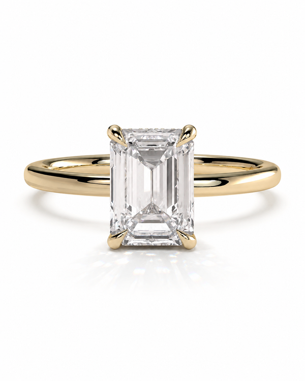 color_10K_YG, color_14K_YG &&
An emerald-cut diamond engagement ring with a yellow gold band, shown on a clean white background with a soft reflection.