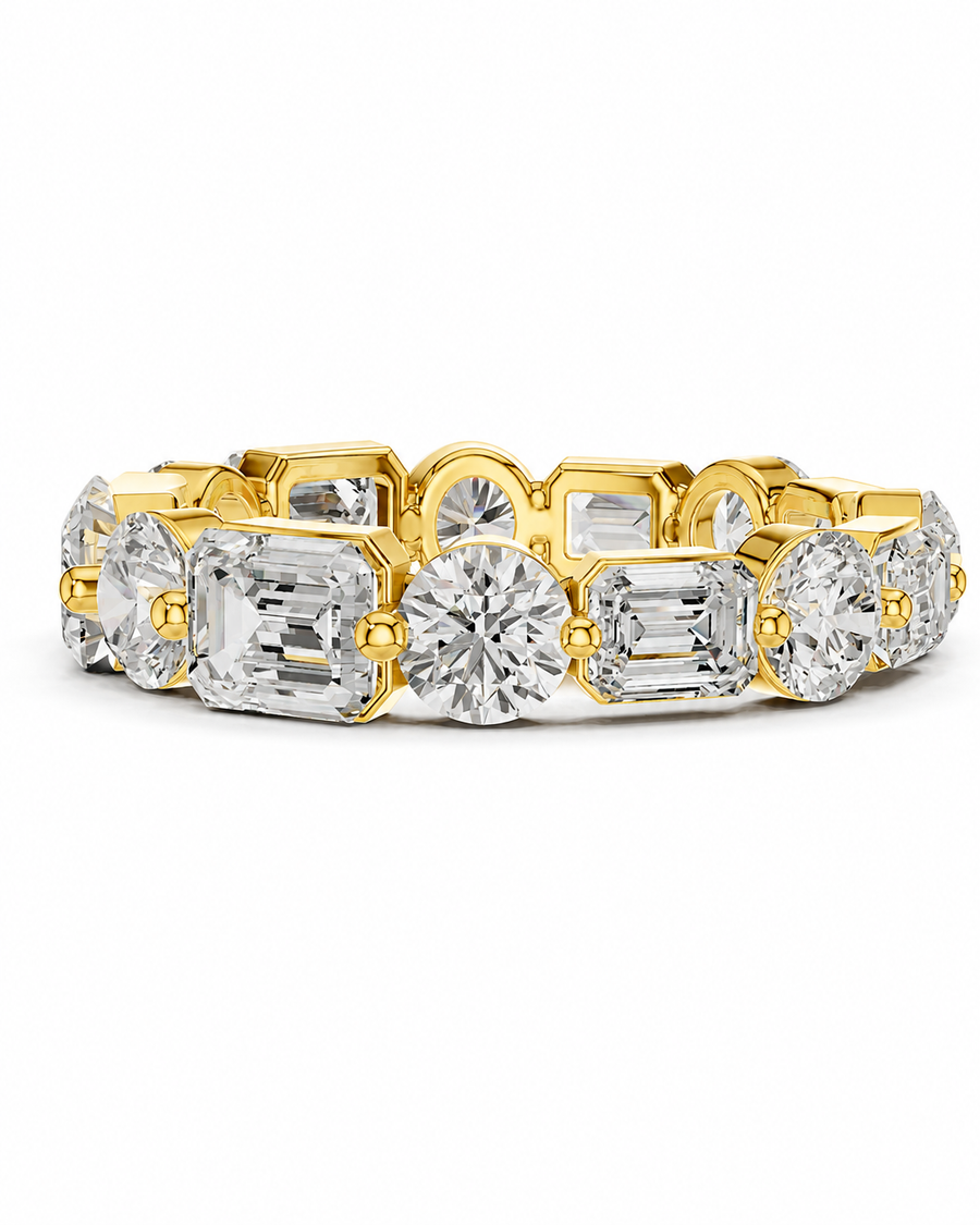 color_10K_YG, color_14K_YG &&	
A yellow gold eternity-style ring featuring a continuous row of clear gemstones in round, oval, and baguette cuts, set against a plain white background.