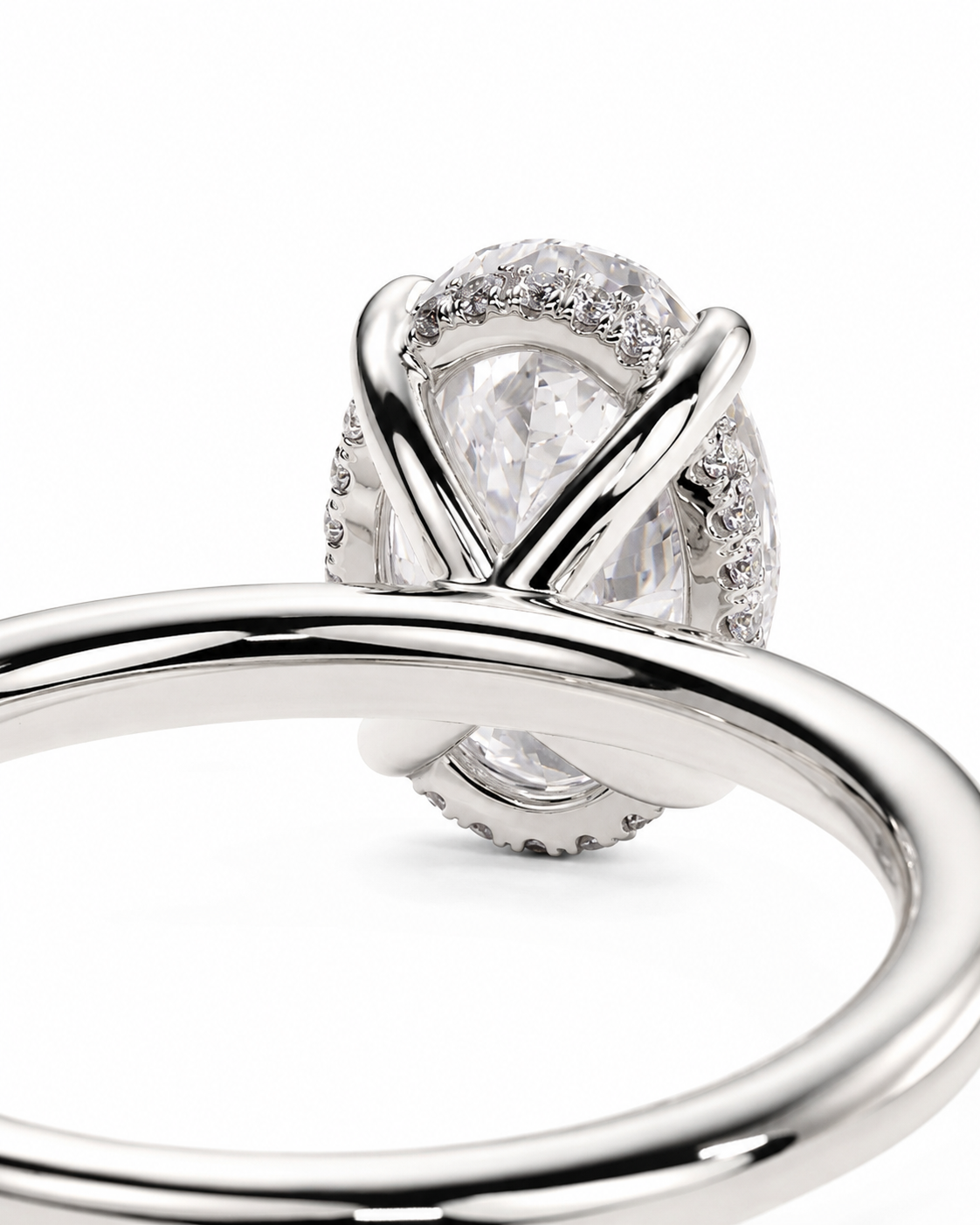 color_925_SIL,color_935_ARG,color_10K_WG, color_14K_WG &&A close-up studio shot of a silver-toned ring featuring a pear-cut clear center stone surrounded by small pave-set clear stones, with a polished band in the foreground on a white background.