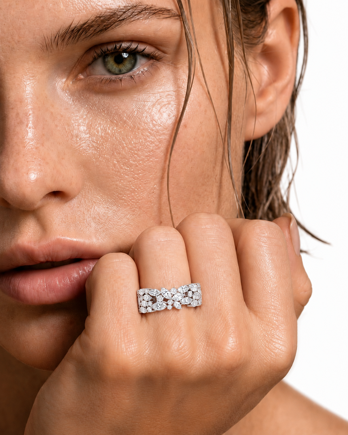 color_925_SIL,color_935_ARG,color_10K_WG, color_14K_WG &&	
A close-up of a model's face and hand wearing a silver band ring set with small round clear gemstones, photographed against a clean white background.