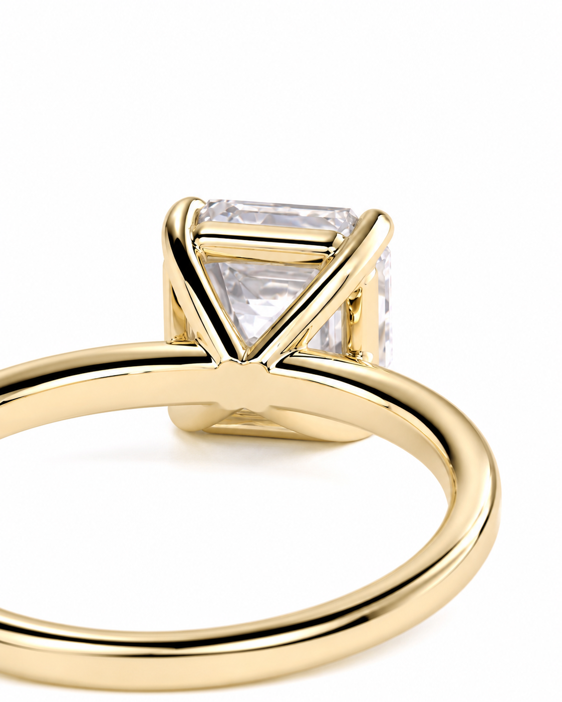 color_10K_YG, color_14K_YG &&A close-up shot of a gold ring featuring a triangular bezel setting with a clear rectangular gemstone, set against a plain white background.