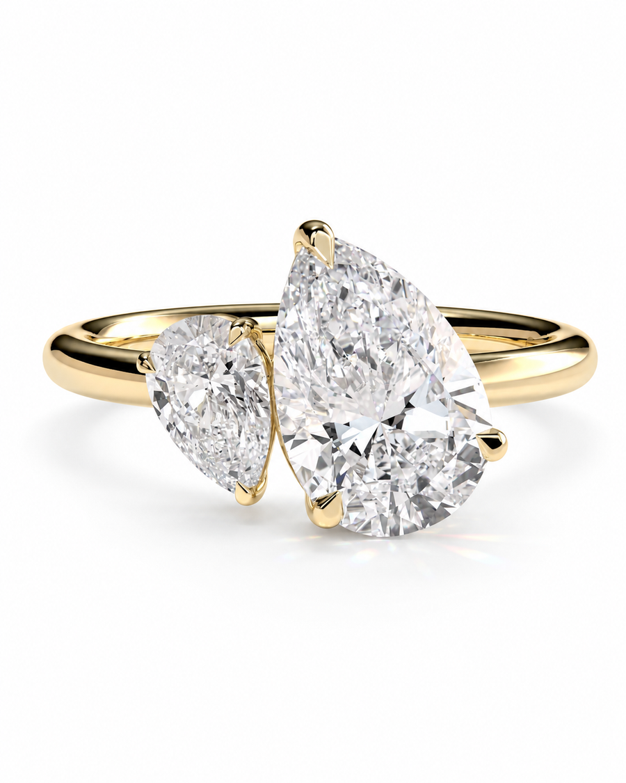 color_10K_YG, color_14K_YG &&A yellow gold ring featuring two pear-cut diamonds, one larger and one smaller, set on a clean white background.