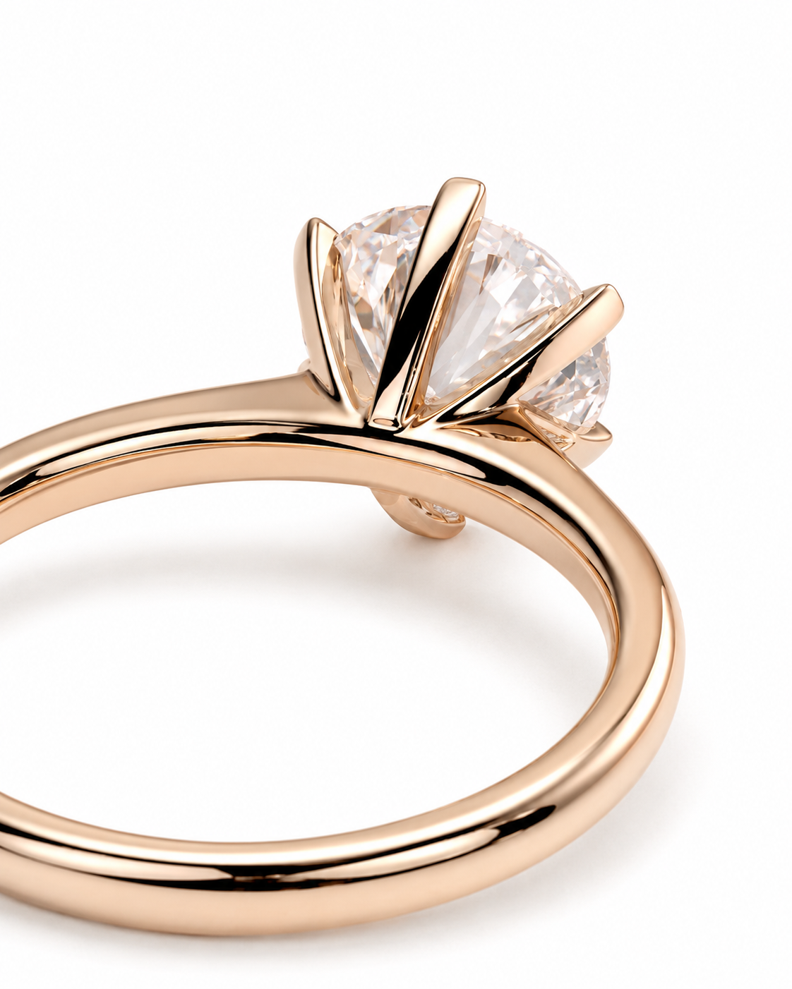 color_10K_RG, color_14K_RG &&A close-up of a rose gold solitaire engagement ring featuring a round brilliant-cut diamond in a four-prong setting, shown on a clean white background.
