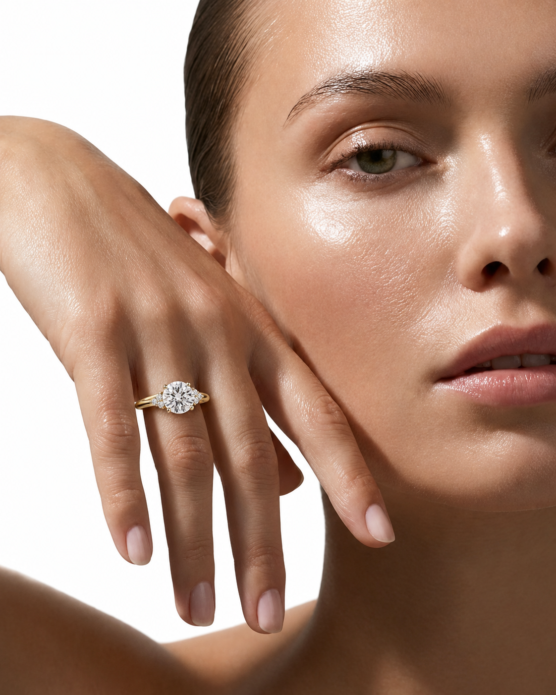 color_10K_YG, color_14K_YG &&A close-up lifestyle shot of a model wearing a yellow gold ring with a round-cut clear gemstone on her finger, set against a clean white background.
