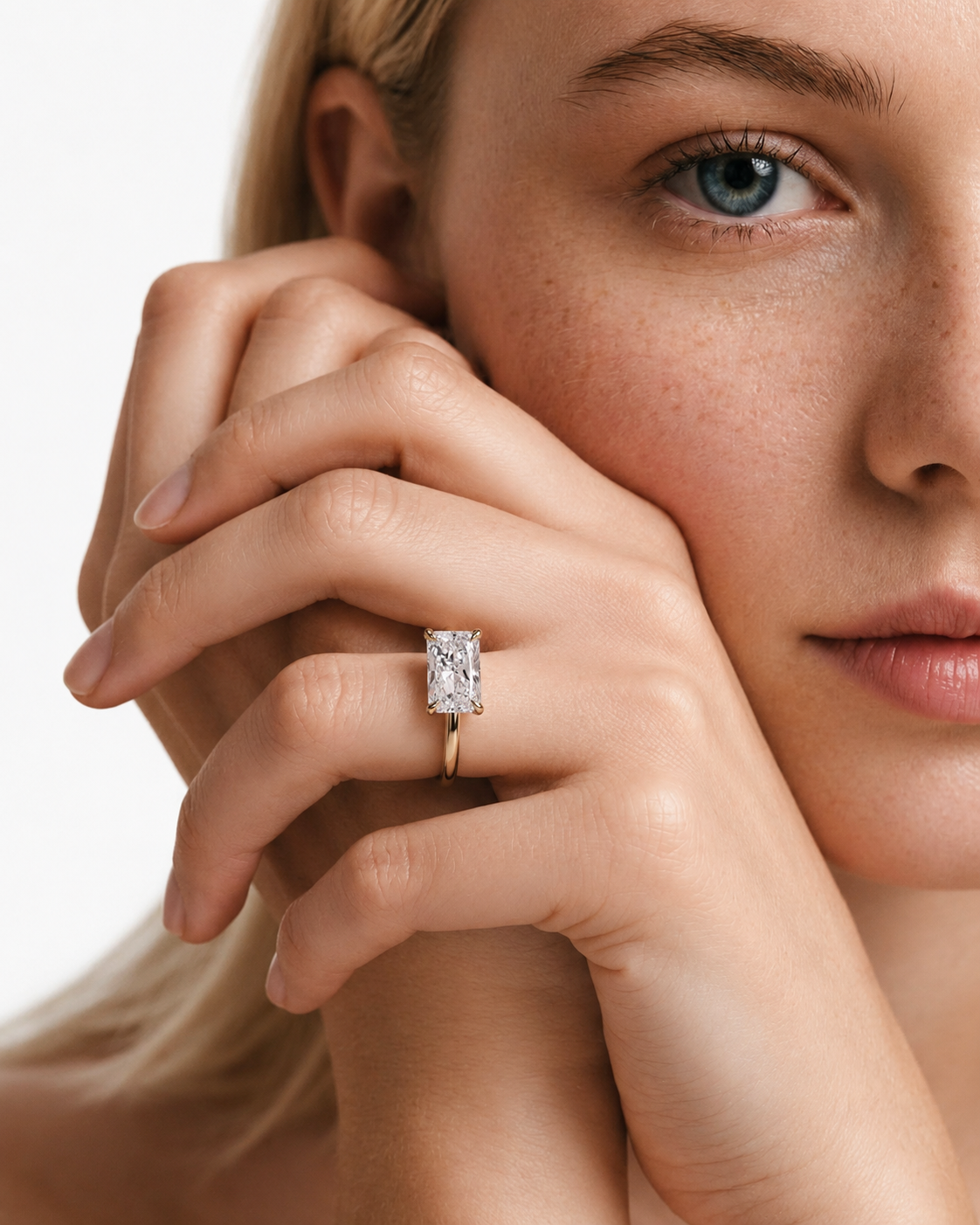 color_10K_YG, color_14K_YG &&A close-up lifestyle shot of a model wearing a yellow gold ring with a rectangular baguette-cut clear gemstone on her finger, set against a clean white background.