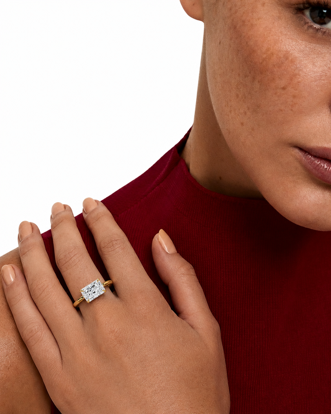 color_10K_YG, color_14K_YG &&
A close-up lifestyle shot of a model wearing a gold ring with a square-cut clear gemstone on her finger, set against a clean white background.
