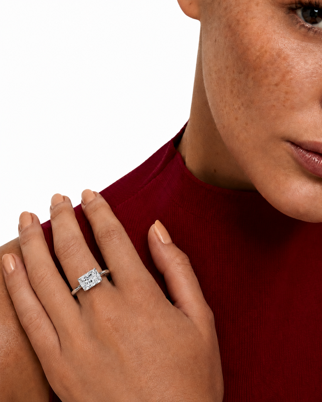 color_925_SIL,color_935_ARG,color_10K_WG, color_14K_WG &&
A close-up lifestyle shot of a model wearing a silver-toned ring with a rectangular clear gemstone on her finger, paired with a dark red ribbed top against a white background.