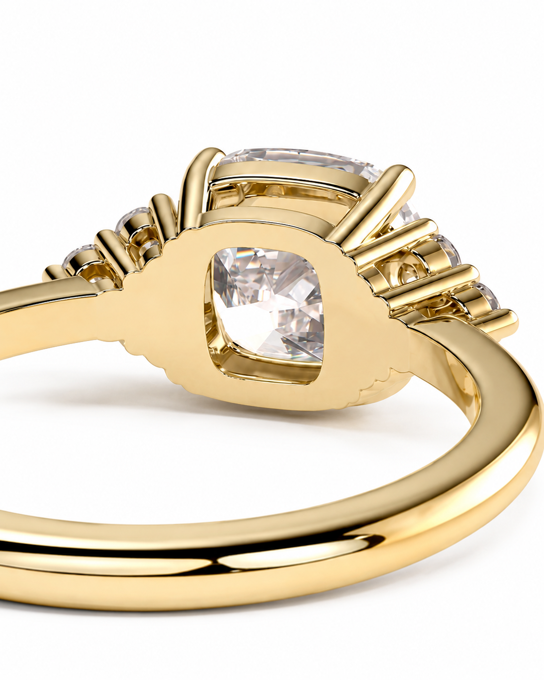 color_10K_YG, color_14K_YG &&A close-up shot of a yellow gold ring featuring a cushion-cut clear center stone and smaller side stones, set against a plain white background.