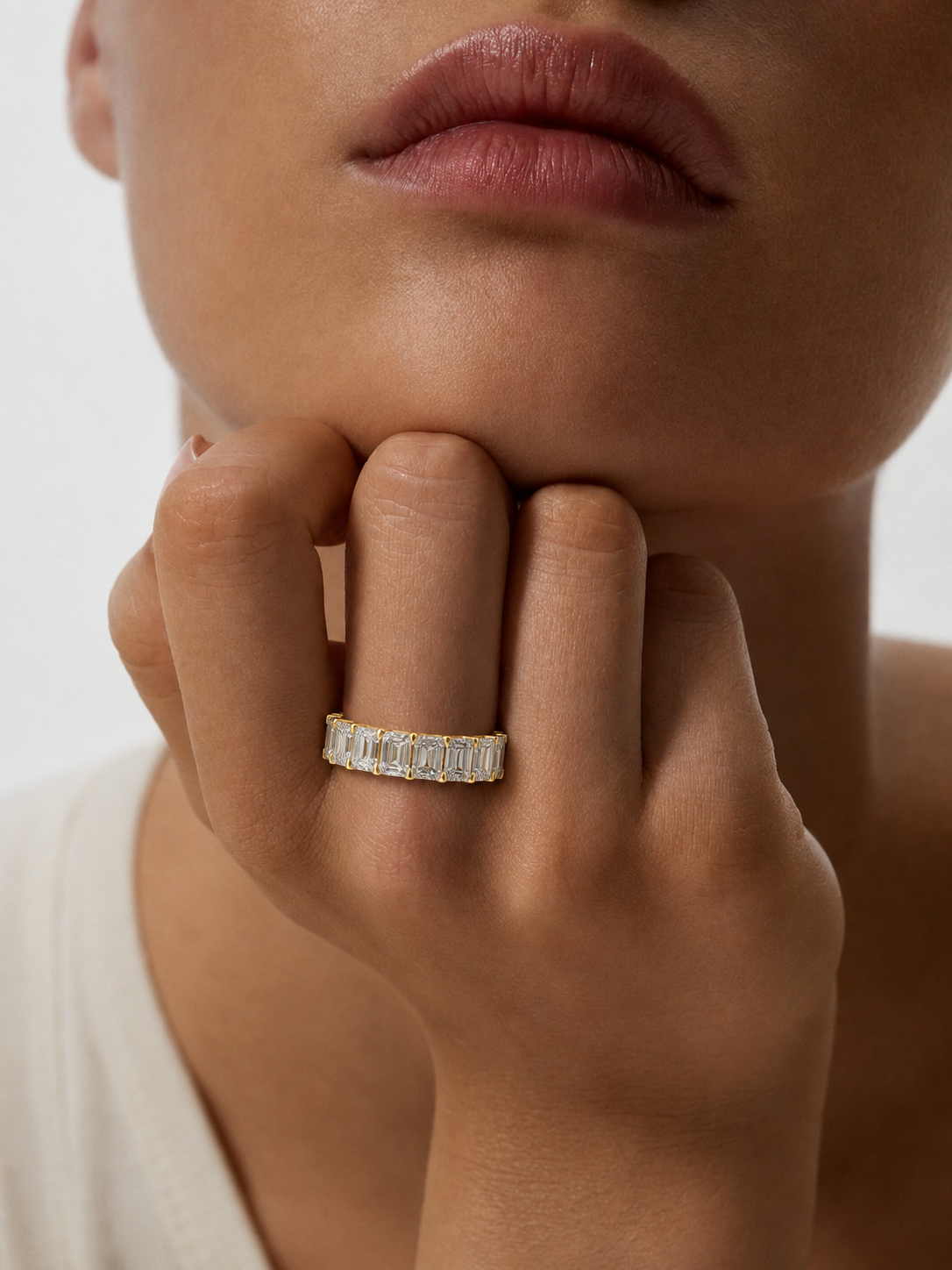 color_10K_YG, color_14K_YG &&Premium full eternity wedding ring with emerald-cut moissanite stones photographed from an elevated angle.