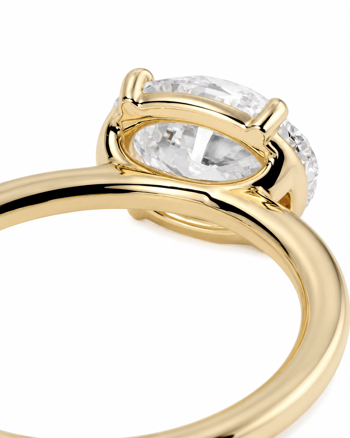 color_10K_YG, color_14K_YG &&A close-up of a yellow gold ring featuring a large oval clear gemstone in a prong setting, with smaller round side stones, shown on a white background.