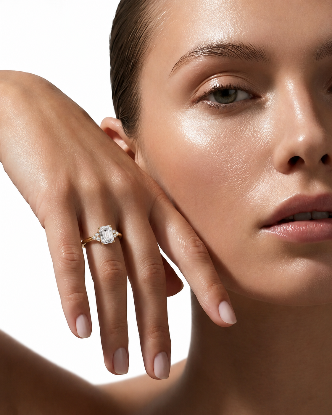 color_10K_YG, color_14K_YG &&A close-up lifestyle shot of a model wearing a gold ring with a large clear rectangular gemstone on her finger, set against a clean white background.