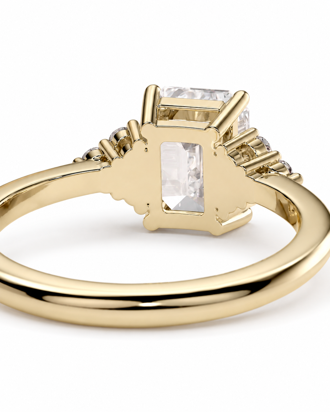 color_10K_YG, color_14K_YG &&A yellow gold ring featuring a rectangular clear gemstone in a prong setting, with smaller accent stones on either side of the band, shown on a white background.