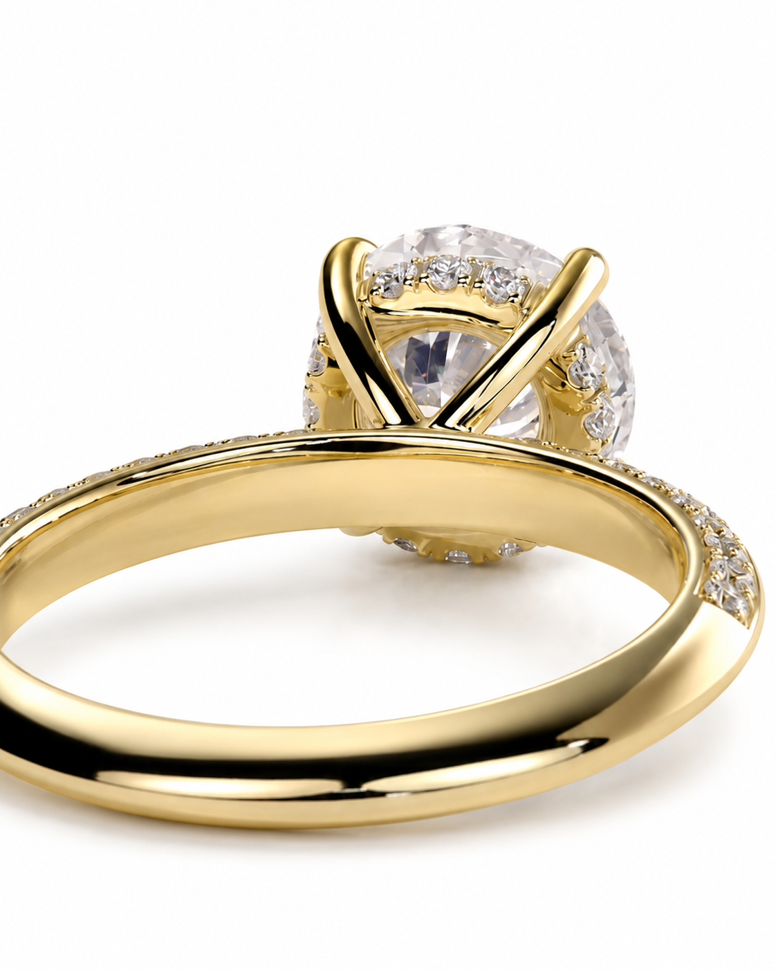 color_10K_YG, color_14K_YG &&A close-up of a yellow gold ring with a large round clear gemstone in a prong setting, with smaller clear stones along the band, shown on a white background.