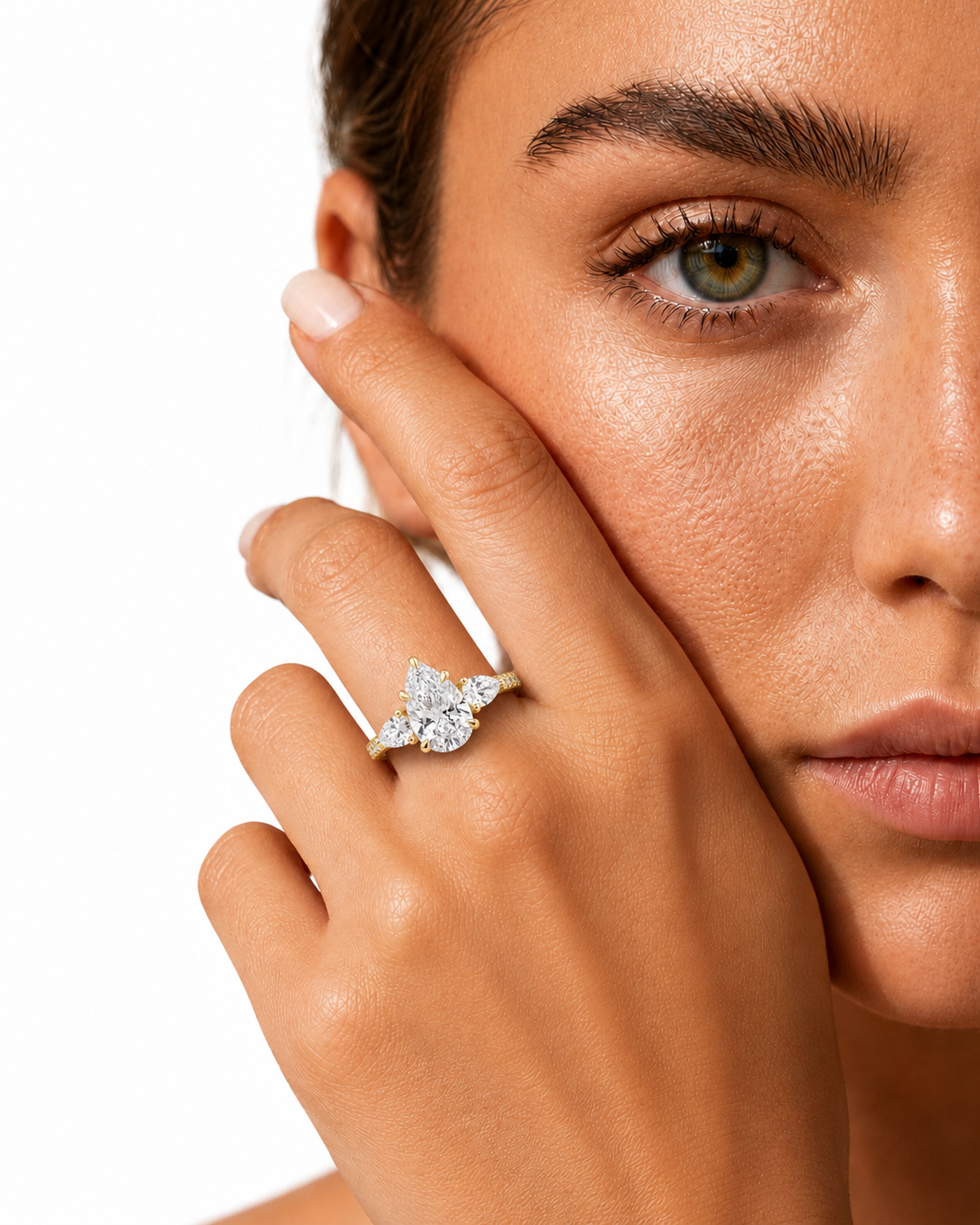 color_10K_YG, color_14K_YG &&A close-up lifestyle shot of a model wearing a diamond ring on her finger, with her face partially visible against a clean white background.