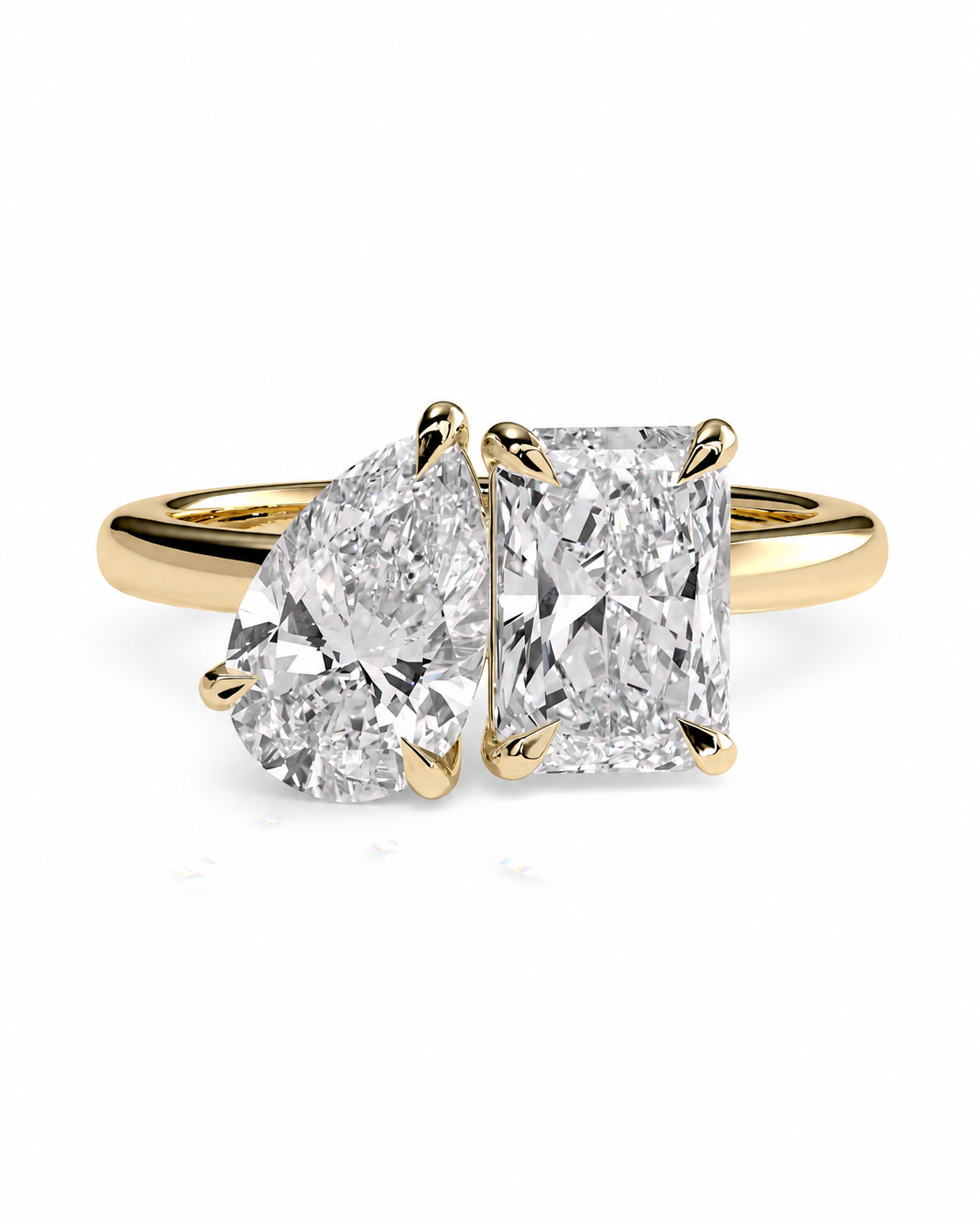 color_10K_YG, color_14K_YG &&A yellow gold ring featuring a pear-cut diamond on the left and a rectangular princess-cut diamond on the right, set in a split-shank band against a white background.
