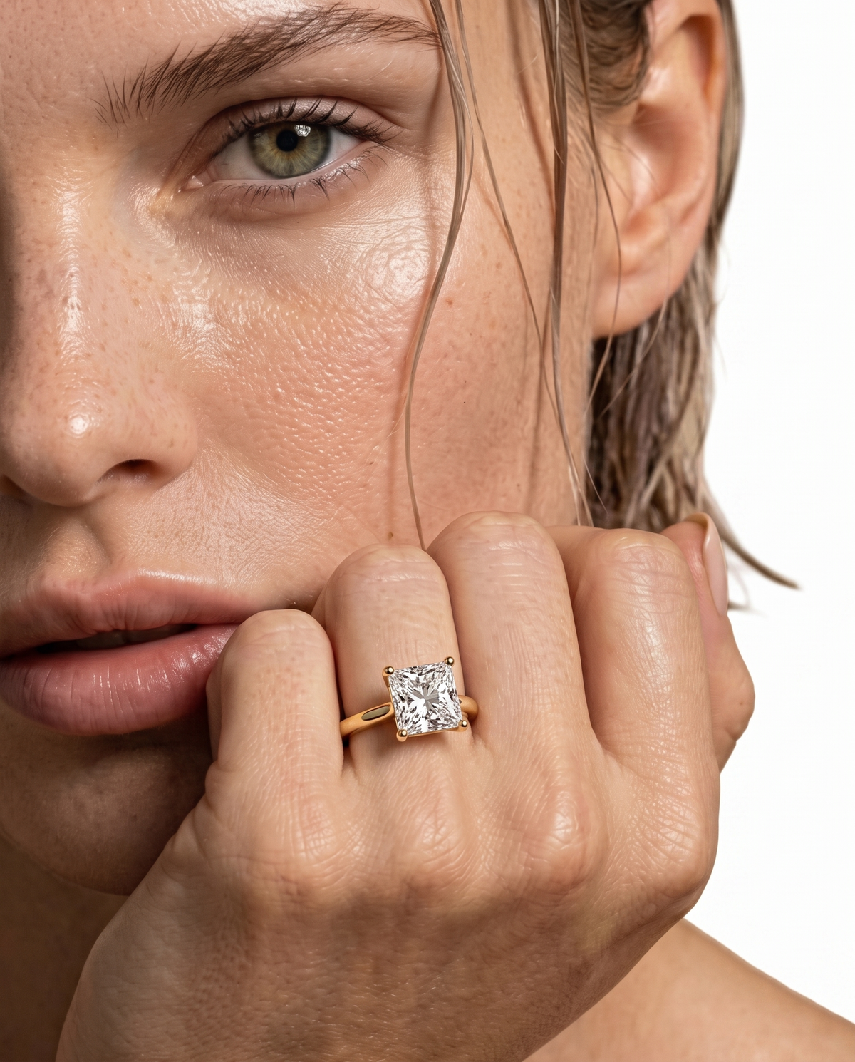 color_10K_YG, color_14K_YG &&A close-up lifestyle shot of a model wearing a yellow gold ring with a square princess-cut diamond on a white background.