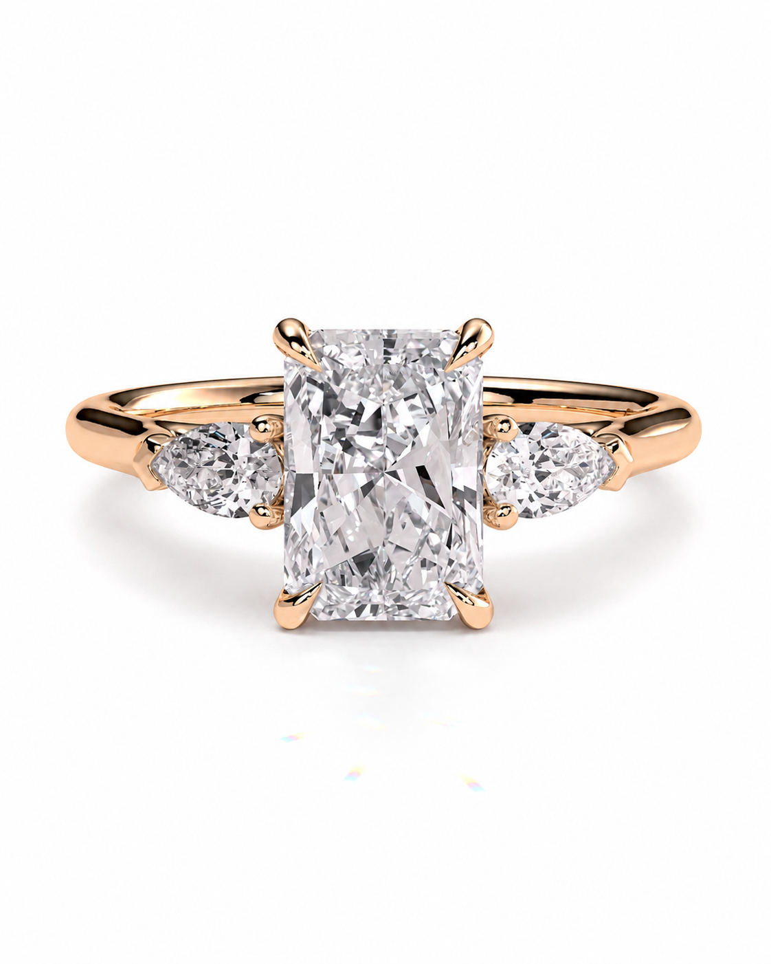 color_10K_RG, color_14K_RG &&
A rose gold engagement ring featuring a large rectangular emerald-cut center diamond flanked by two smaller round diamonds on a white background.