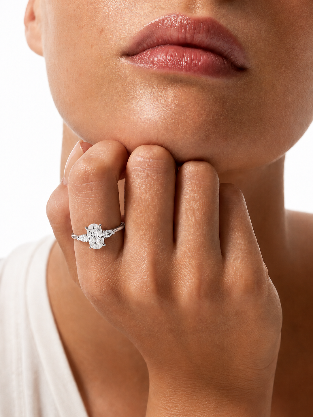 color_925_SIL,color_935_ARG,color_10K_WG, color_14K_WG &&
A close-up of a model's hand resting on their chin, wearing a silver-toned diamond ring with a floral cluster centerstone and smaller side stones.