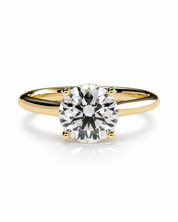 color_10K_YG, color_14K_YG &&	
A classic solitaire engagement ring featuring a round brilliant-cut diamond set in a yellow gold four-prong band, shown on a clean white background with a soft reflection.