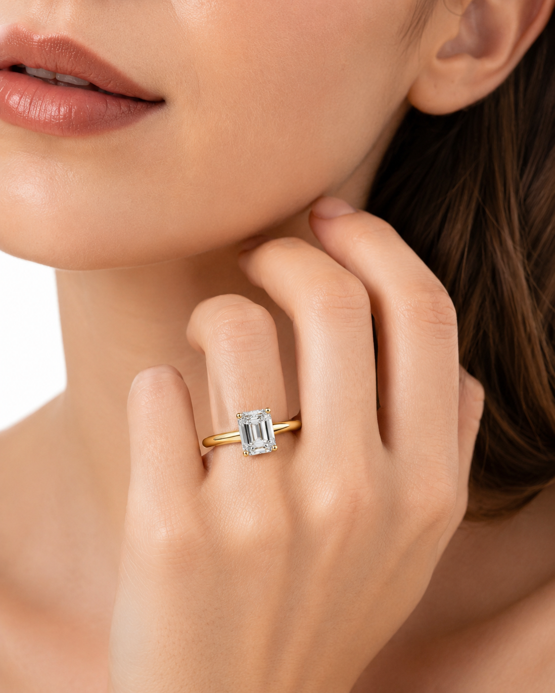 color_10K_YG, color_14K_YG &&	
A close-up lifestyle shot of a model wearing a yellow gold ring with a rectangular baguette-cut clear gemstone on her finger.