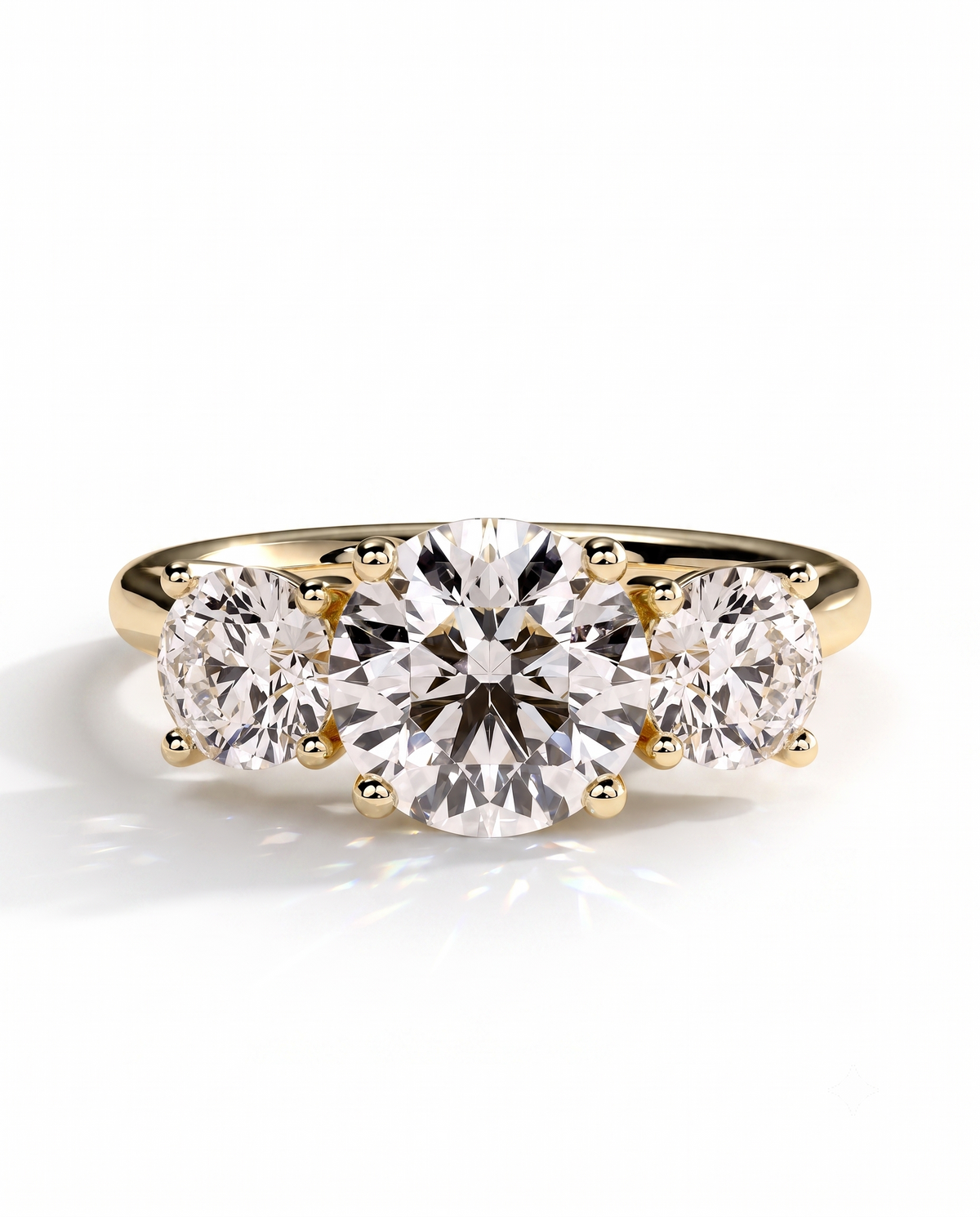 color_10K_YG, color_14K_YG &&	
A yellow gold three-stone engagement ring featuring a large round center diamond flanked by two smaller round side diamonds, set against a clean white background.