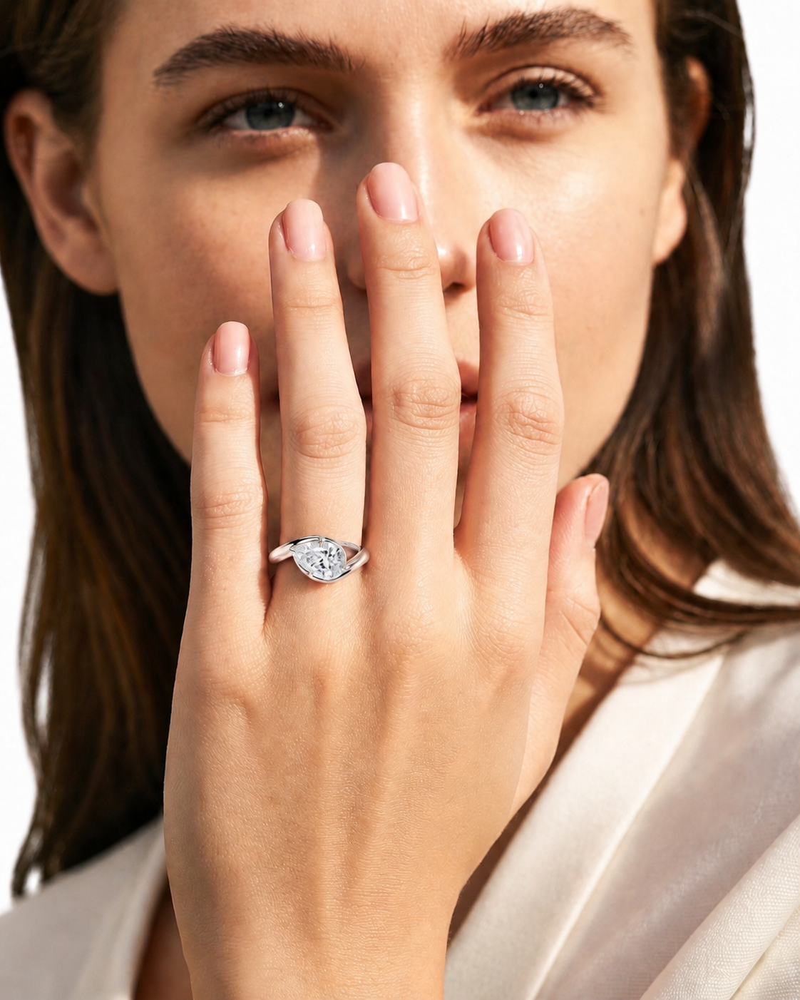 color_925_SIL,color_935_ARG,color_10K_WG, color_14K_WG &&
A close-up lifestyle shot of a woman wearing a gold ring with a marquise-cut clear gemstone, holding her hand near her face against a white background.
