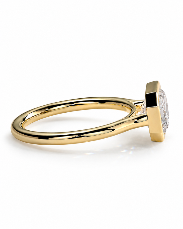 color_10K_YG, color_14K_YG &&	
A yellow gold ring with a square bezel setting holding a clear gemstone, shown from a side angle on a white background.