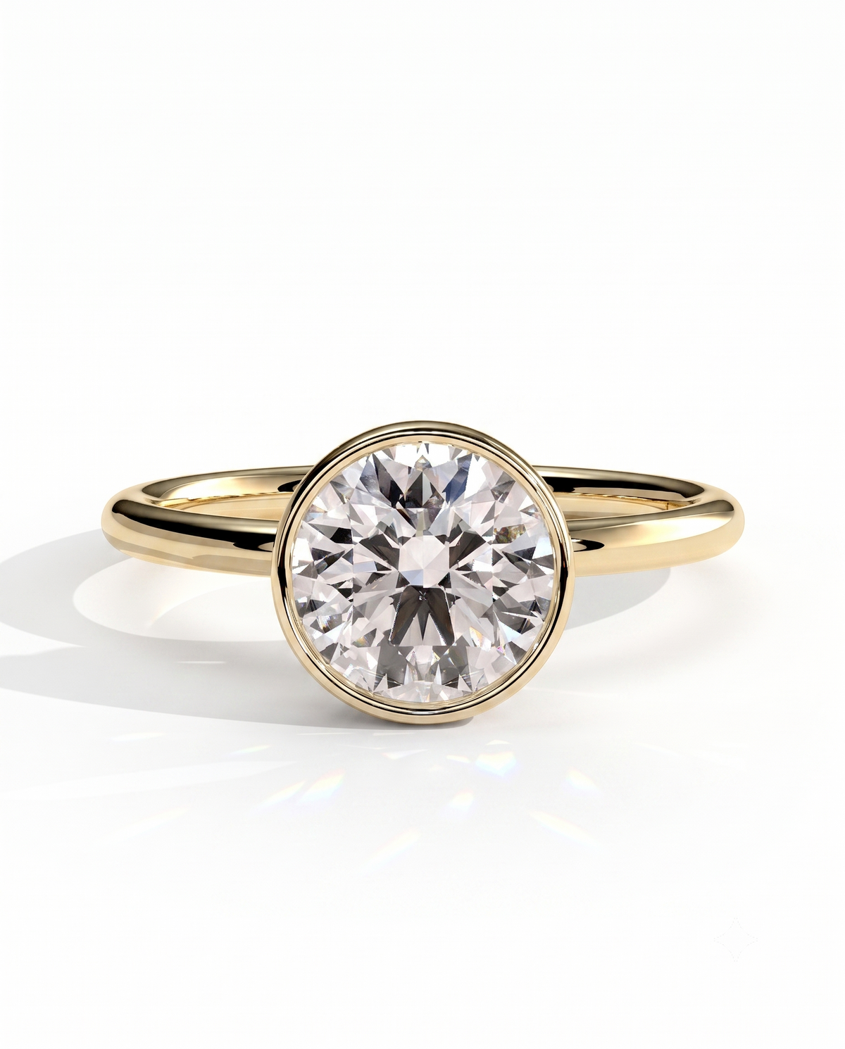 color_10K_YG, color_14K_YG &&	
A yellow gold solitaire engagement ring featuring a round brilliant-cut diamond center stone in a bezel setting, shown on a clean white background with a soft reflection.