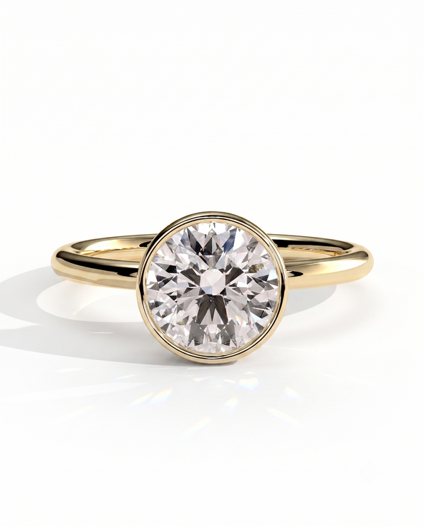 color_10K_YG, color_14K_YG &&	
A yellow gold solitaire engagement ring featuring a round brilliant-cut diamond center stone in a bezel setting, shown on a clean white background with a soft reflection.