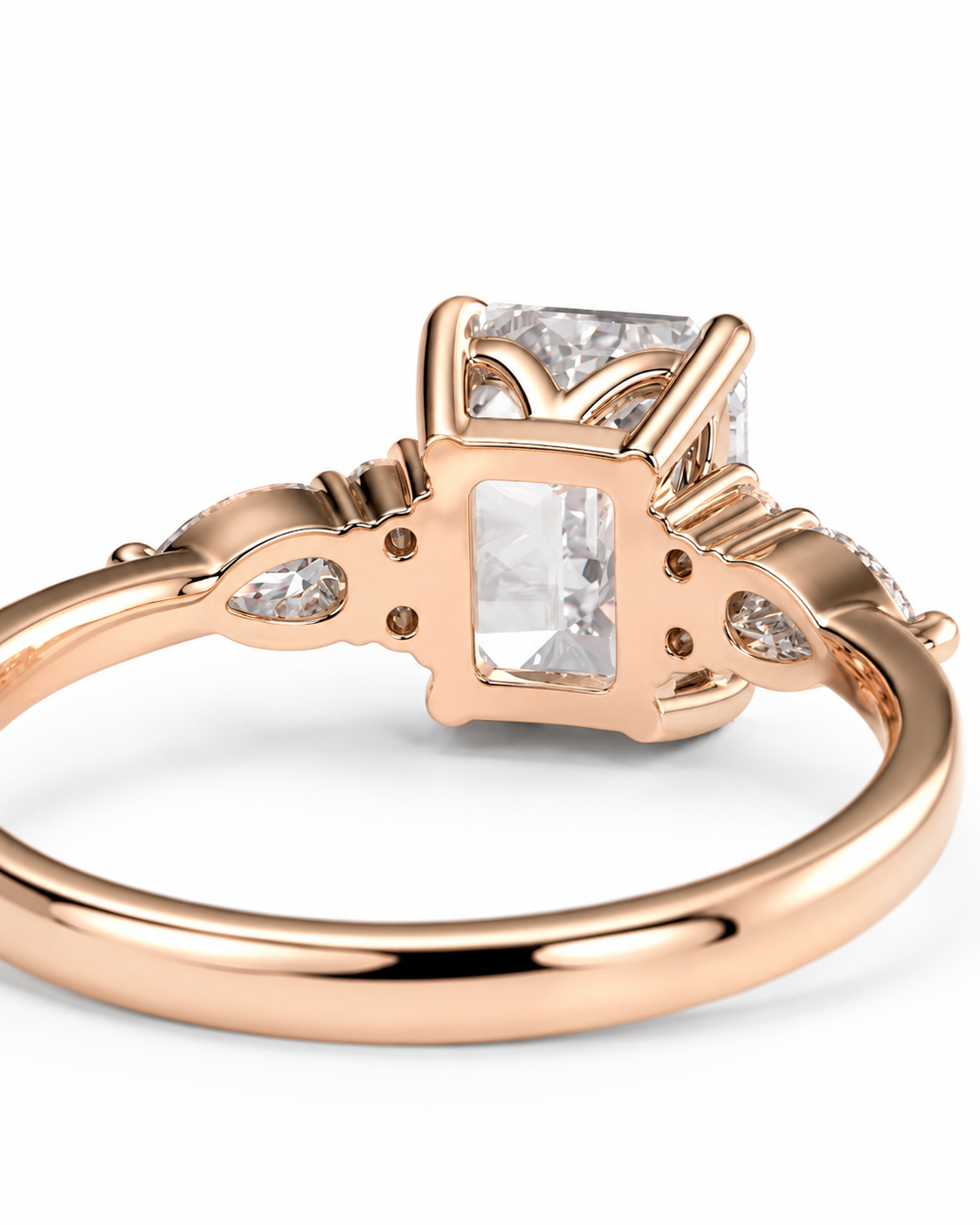 color_10K_RG, color_14K_RG &&Rose gold ring with a rectangular clear gemstone in a cushion-cut setting, accented by smaller round and marquise-cut clear stones on the band, shown on a white background.