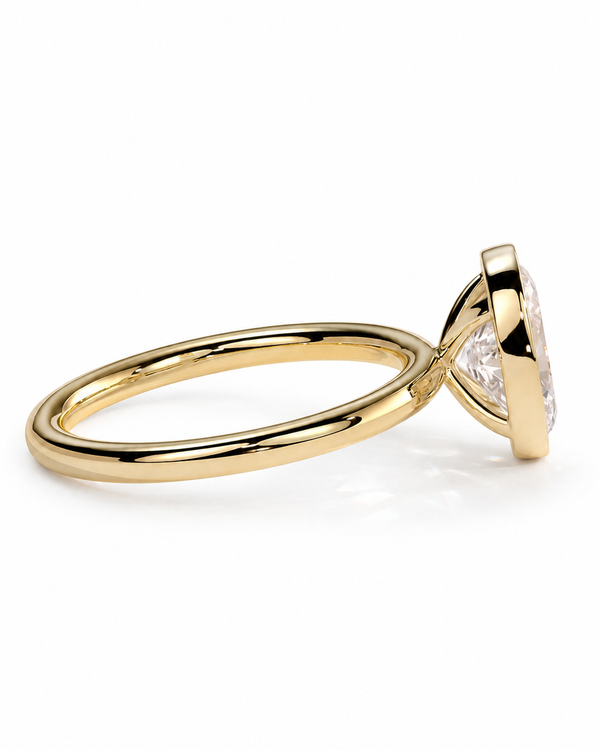 color_10K_YG, color_14K_YG &&A yellow gold solitaire ring with a clear round-cut gemstone in a prong setting, shown from a side angle on a white background.