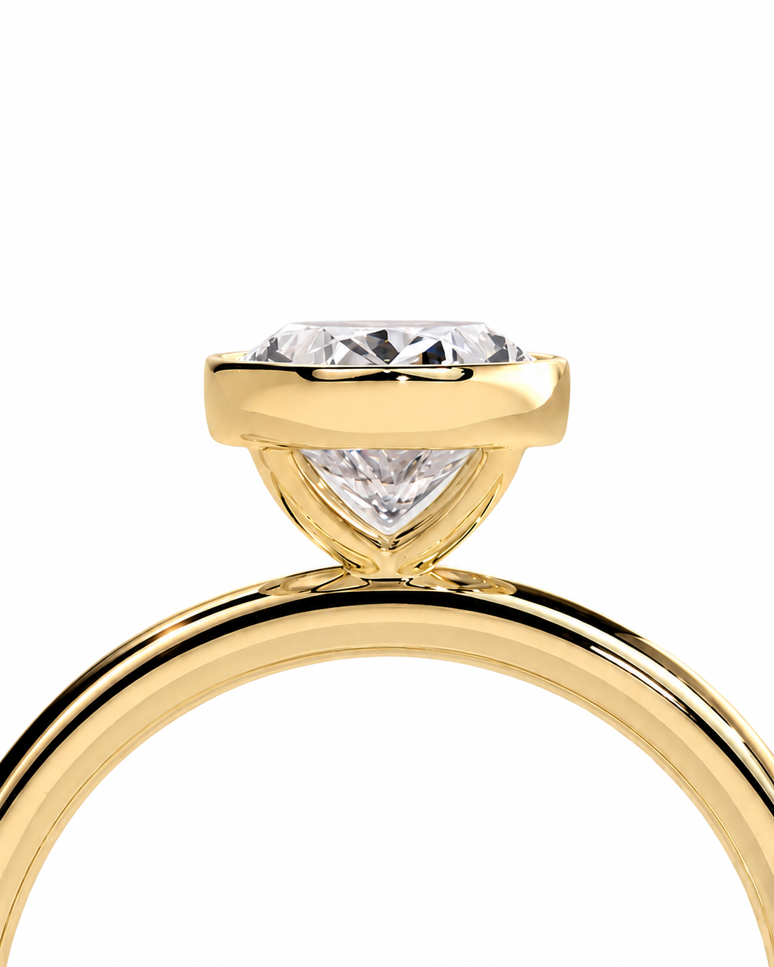 color_10K_YG, color_14K_YG &&A close-up of a yellow gold solitaire engagement ring featuring a brilliant round-cut diamond in a prong setting with a triangular diamond accent below, on a plain white background.