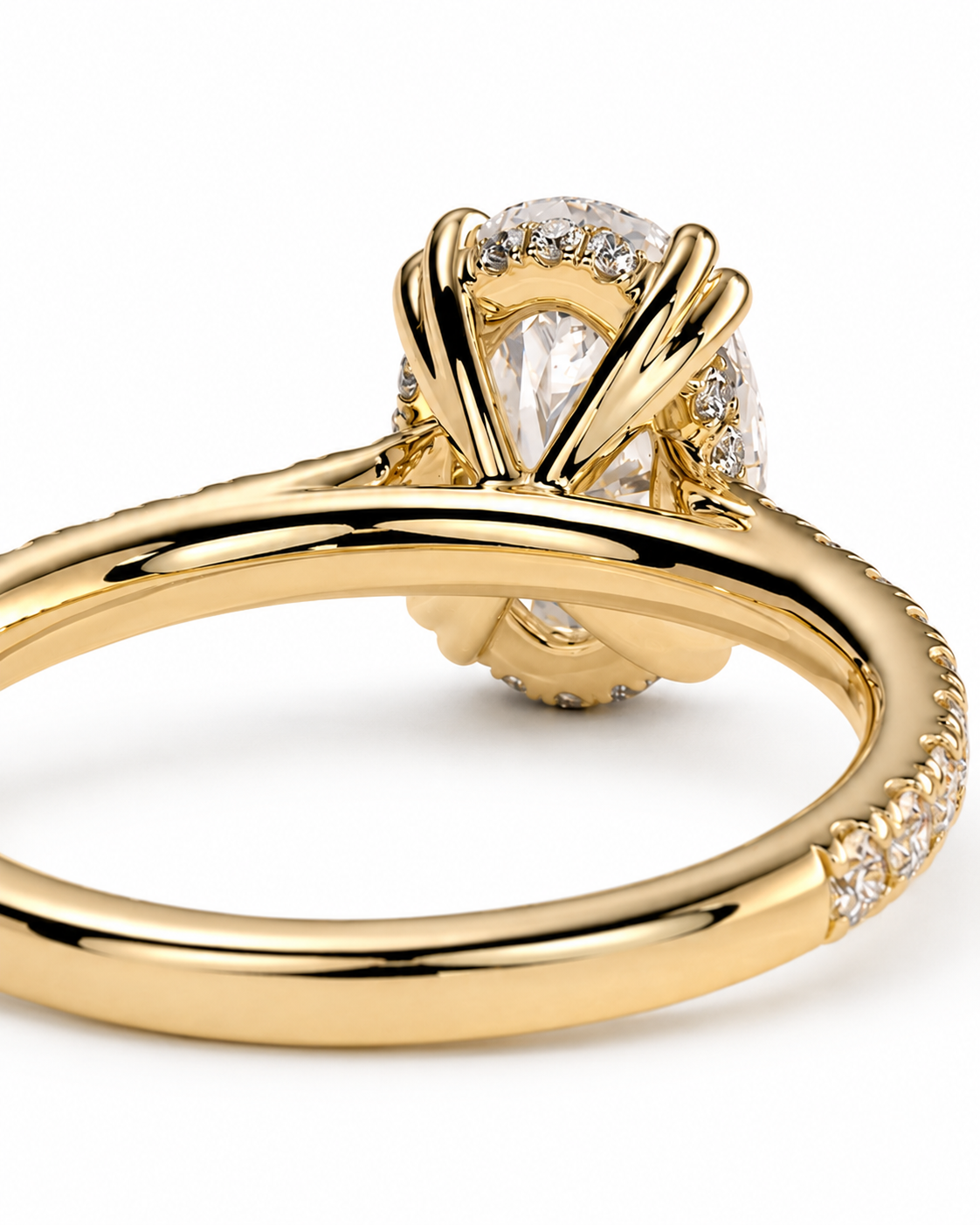 color_10K_YG, color_14K_YG &&A close-up of a yellow gold ring featuring a pear-cut clear center stone in a halo setting, with small pavé diamonds along the band, shown on a white background.