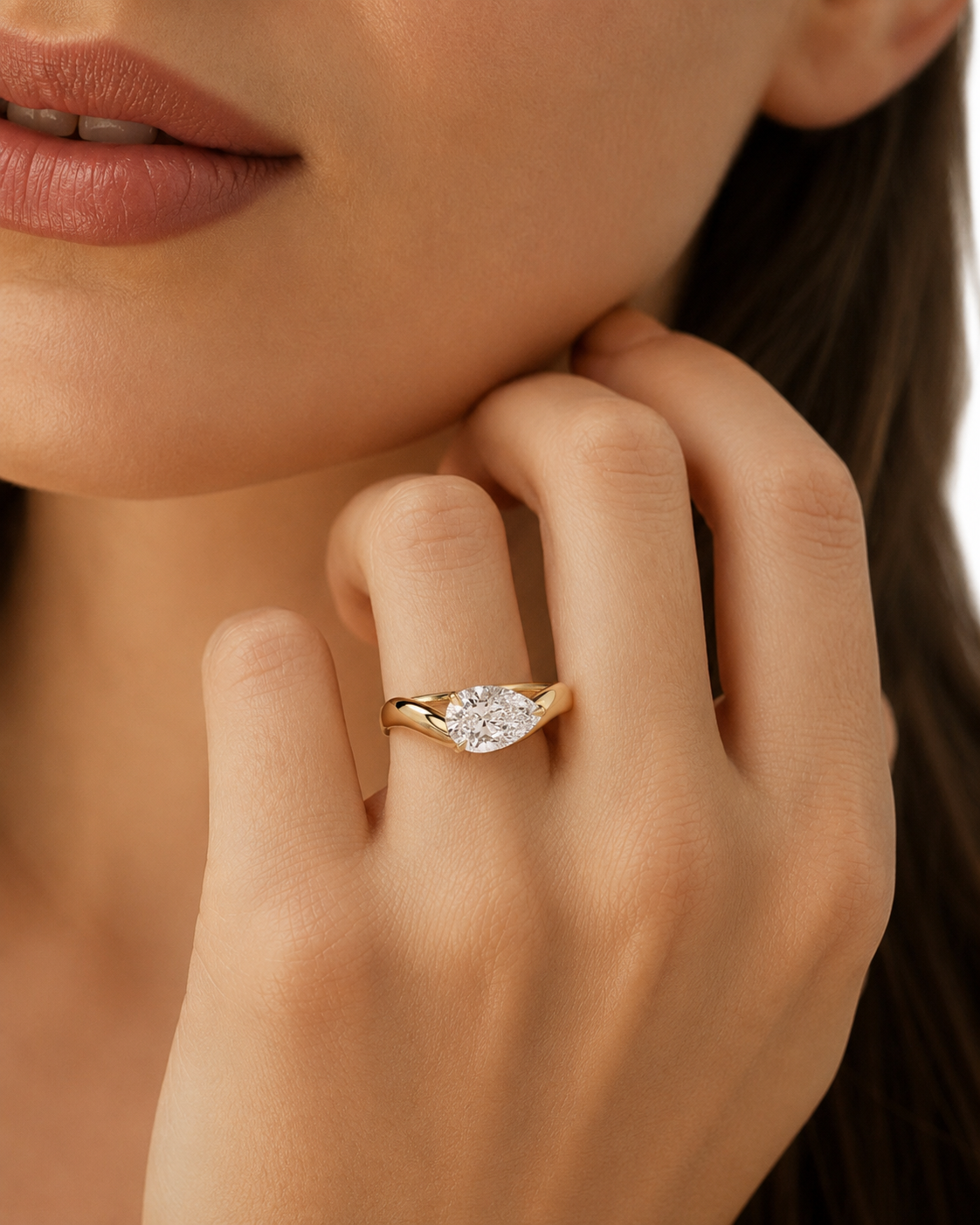 color_10K_YG, color_14K_YG &&A close-up lifestyle shot of a model wearing a yellow gold marquise-cut diamond engagement ring on her finger.