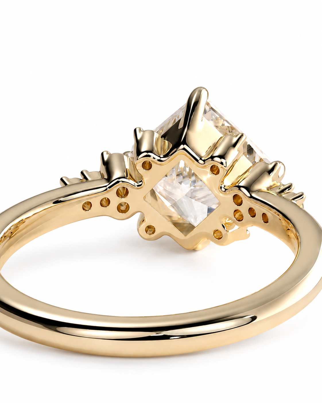 color_10K_YG, color_14K_YG &&A close-up shot of a gold ring featuring a unique starburst halo design around a princess-cut clear center stone, set against a plain white background.
