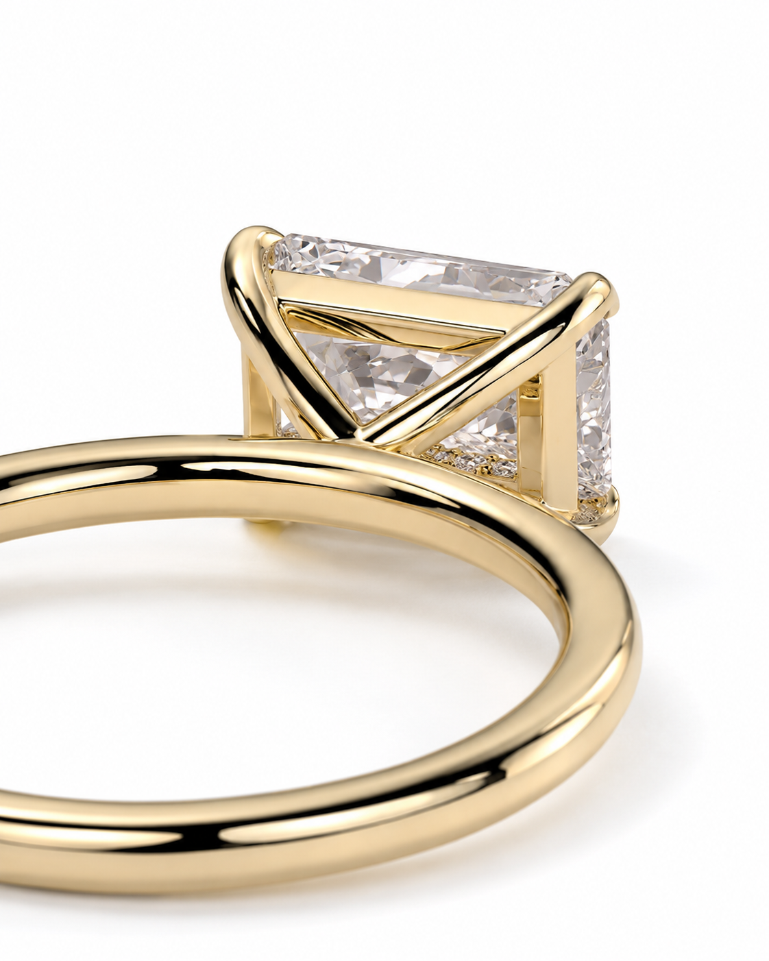 color_10K_YG, color_14K_YG &&A close-up of a gold ring featuring a rectangular clear gemstone in a unique crisscross prong setting, shown on a clean white background.