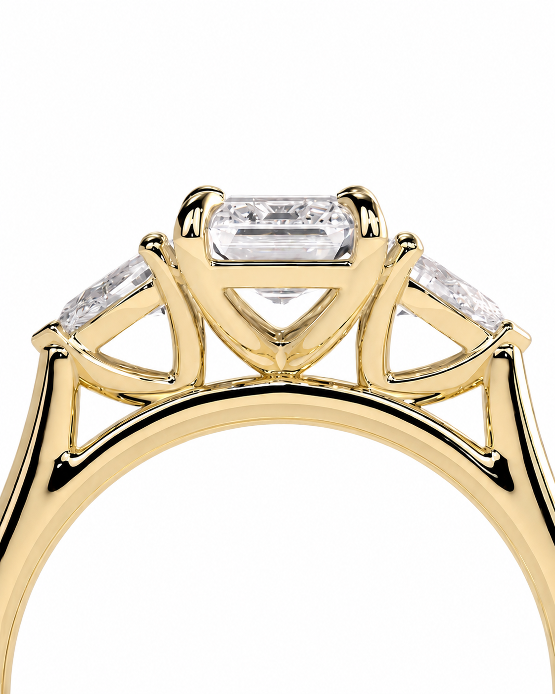 color_10K_YG, color_14K_YG &&A close-up of a yellow gold ring setting featuring a central baguette-cut clear gemstone flanked by two smaller round-cut clear gemstones, shown against a plain white background.