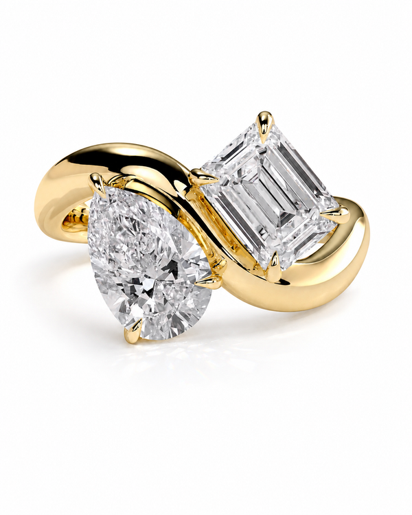 color_10K_YG, color_14K_YG &&A yellow gold ring featuring a pear-cut diamond on one side and an emerald-cut diamond on the other, set against a clean white background.
