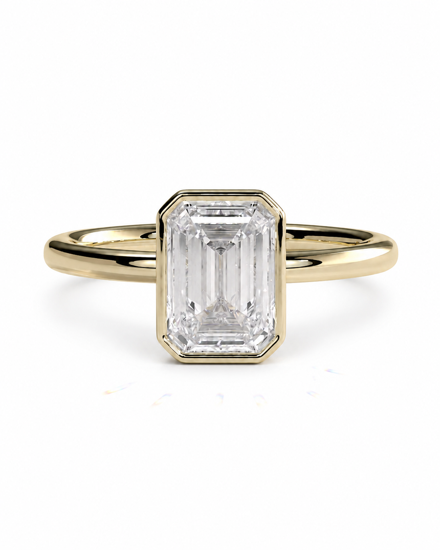 color_10K_YG, color_14K_YG &&A yellow gold ring featuring a large rectangular emerald-cut clear gemstone in a beveled setting, shown against a plain white background.