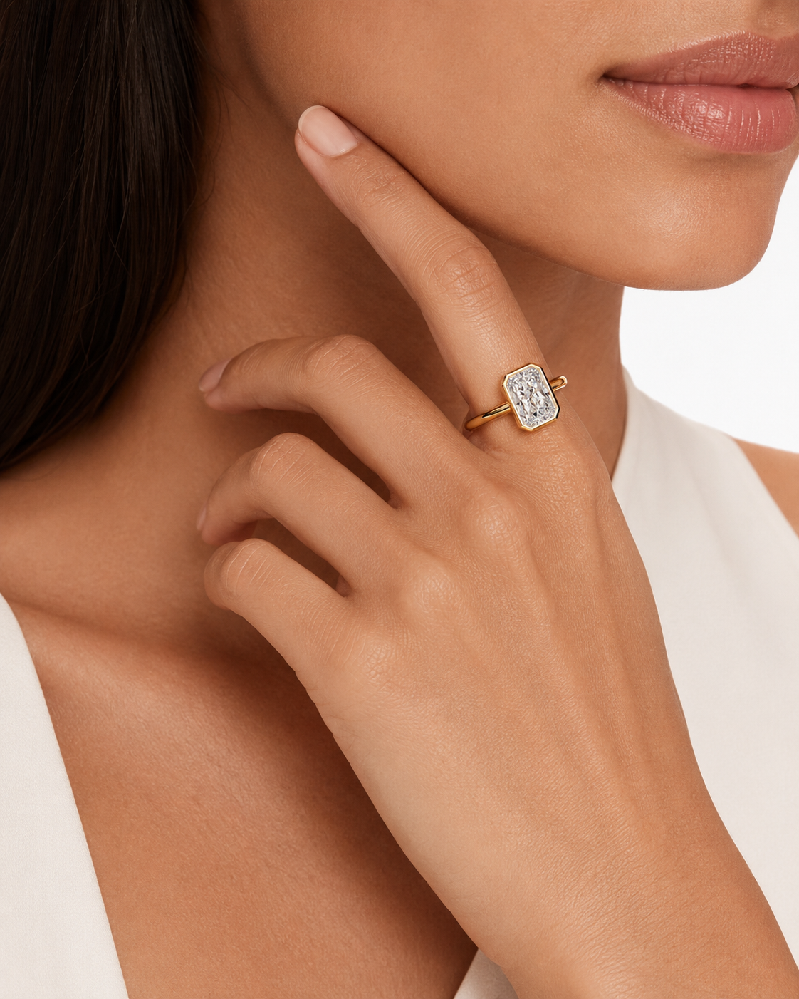 color_10K_YG, color_14K_YG &&A close-up lifestyle shot of a model wearing a gold ring with a rectangular clear gemstone featuring an engraved monogram.
